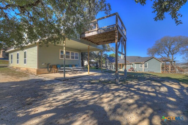 exterior space featuring a wooden deck and a patio area