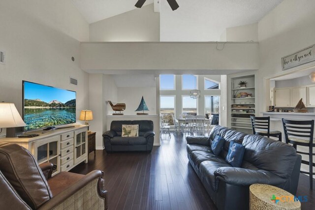 living room with dark hardwood / wood-style flooring, high vaulted ceiling, ceiling fan, and built in shelves