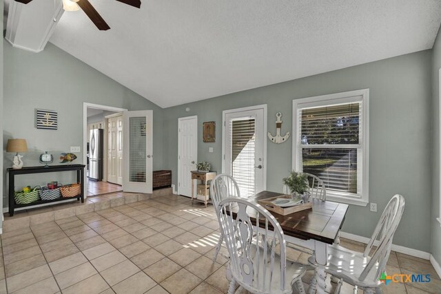 tiled dining space featuring lofted ceiling, a textured ceiling, ceiling fan, and french doors