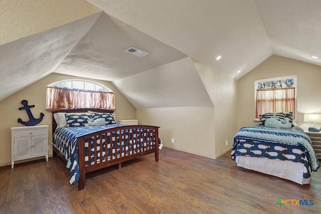 bedroom featuring dark wood-type flooring, lofted ceiling, and a textured ceiling