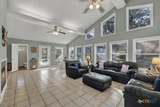 living room with ceiling fan, light tile patterned floors, and beam ceiling