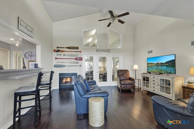 living room featuring french doors, ceiling fan, dark hardwood / wood-style floors, and a textured ceiling