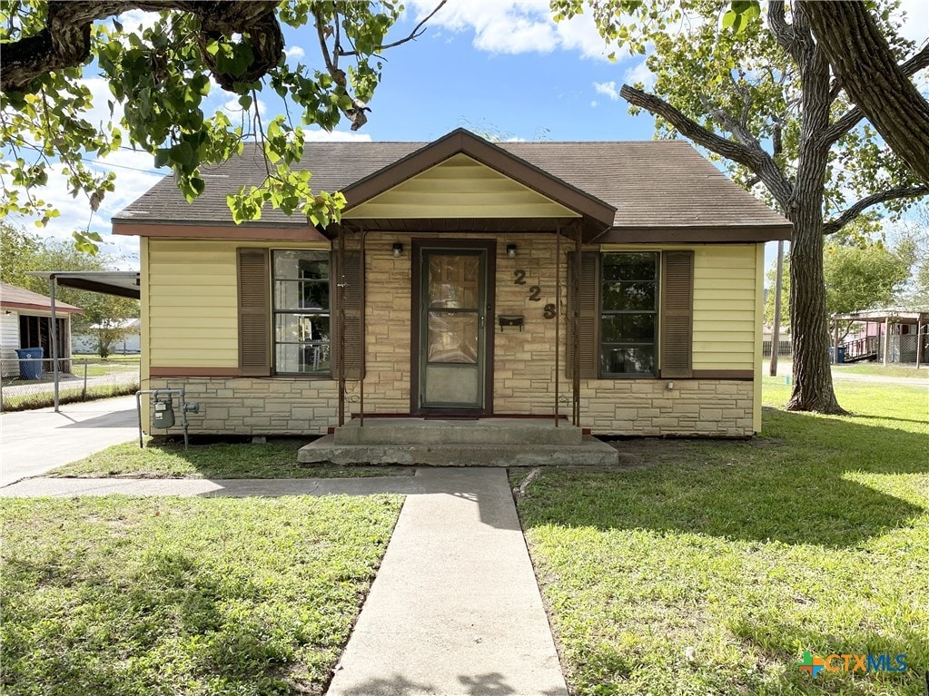 bungalow-style house with a front lawn