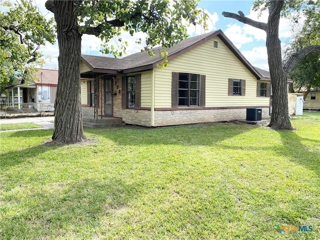 ranch-style house featuring central AC unit and a front lawn