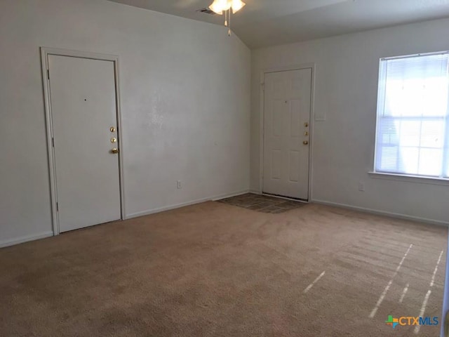 carpeted foyer featuring ceiling fan and vaulted ceiling