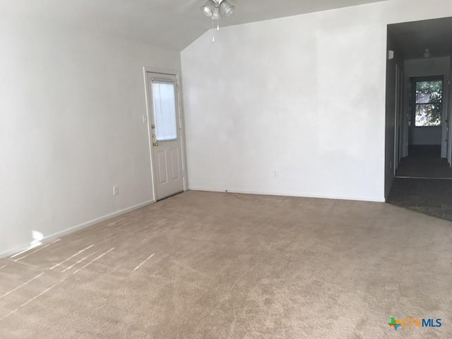 carpeted empty room with ceiling fan and lofted ceiling