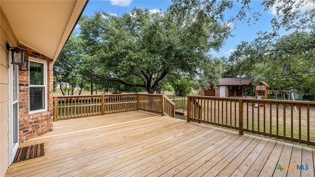 wooden deck with a lawn and a playground