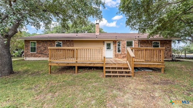 rear view of property with a lawn and a deck