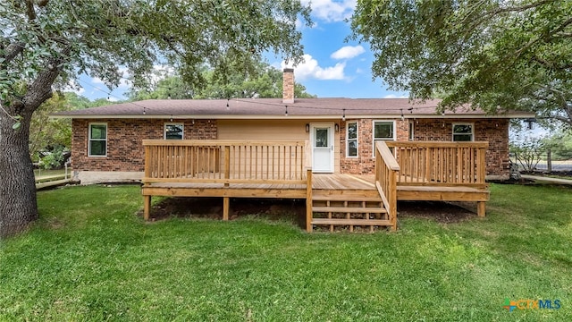 back of house featuring a deck and a lawn