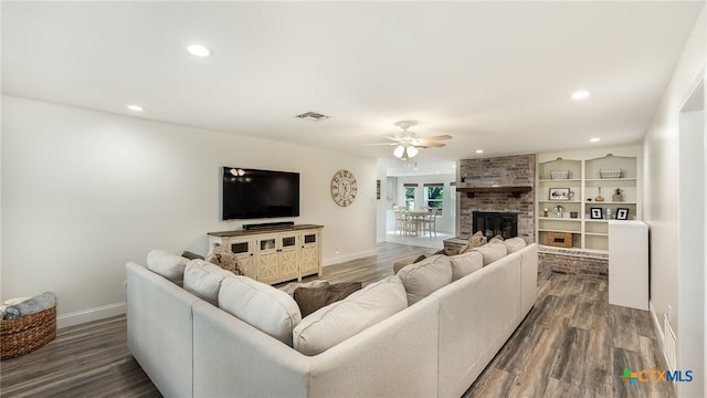 living room with ceiling fan, dark hardwood / wood-style floors, and a brick fireplace