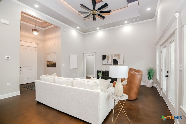 living room with crown molding, a tray ceiling, ceiling fan, and a towering ceiling