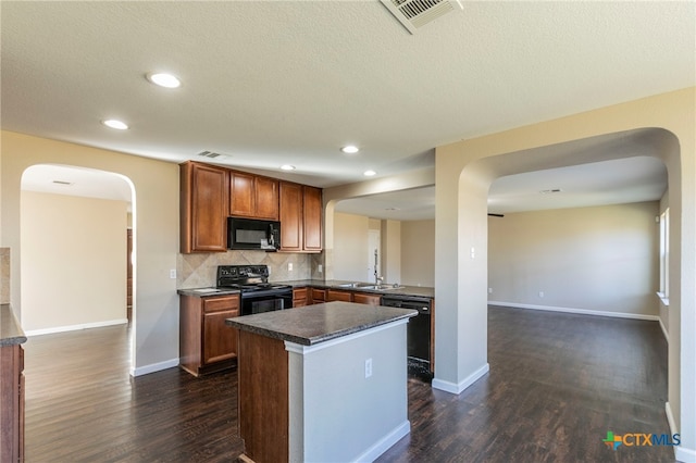 kitchen featuring black appliances, tasteful backsplash, sink, dark wood-type flooring, and kitchen peninsula