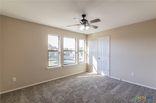 carpeted spare room featuring ceiling fan