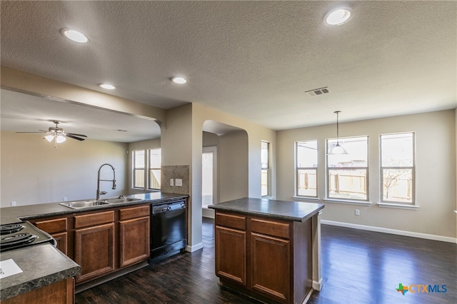 kitchen featuring dark wood-type flooring, a textured ceiling, hanging light fixtures, sink, and dishwasher