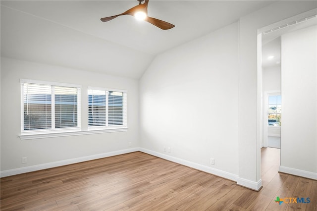 empty room featuring light wood-type flooring, ceiling fan, lofted ceiling, and plenty of natural light