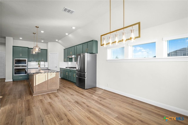 kitchen with decorative light fixtures, decorative backsplash, appliances with stainless steel finishes, and hardwood / wood-style flooring