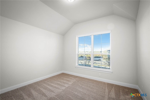 empty room featuring carpet and vaulted ceiling