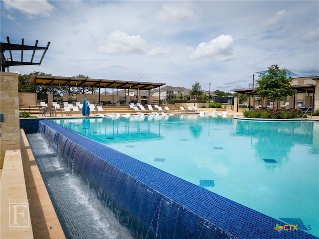 view of swimming pool featuring pool water feature and a patio