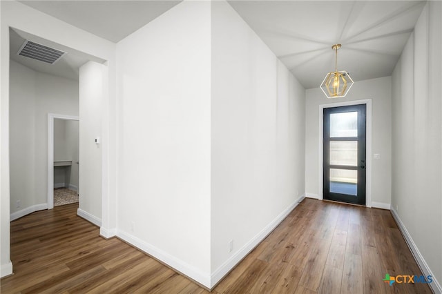 foyer entrance featuring an inviting chandelier and hardwood / wood-style flooring