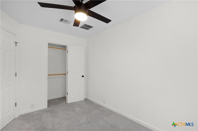 unfurnished bedroom featuring ceiling fan, light carpet, and a closet