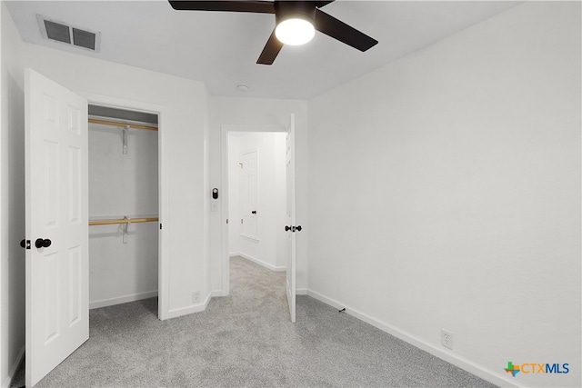 unfurnished bedroom with light carpet, ceiling fan, and a closet