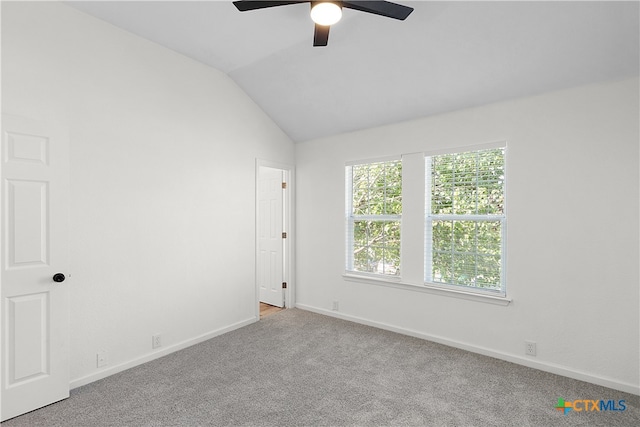 empty room featuring ceiling fan, light carpet, and vaulted ceiling