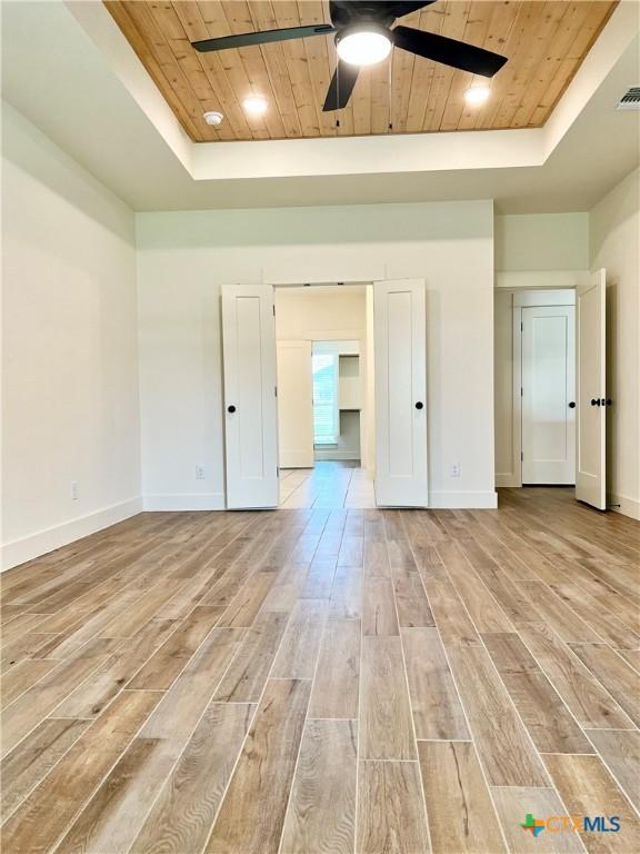 2819 Isaac Cir, Belton, TX 76513 - unfurnished bedroom featuring a raised ceiling, wooden ceiling, light wood-style floors, baseboards, and ceiling fan