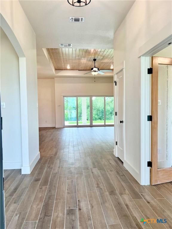 2819 Isaac Cir, Belton, TX 76513 - corridor featuring wood finished floors, baseboards, wooden ceiling, arched walkways, and a tray ceiling