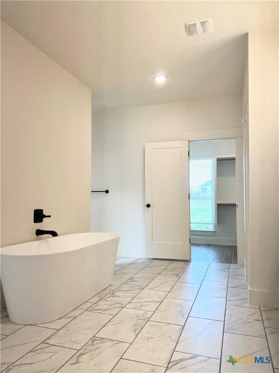 2819 Isaac Cir, Belton, TX 76513 - bathroom with marble look tiles, a soaking tub, baseboards, and recessed lighting