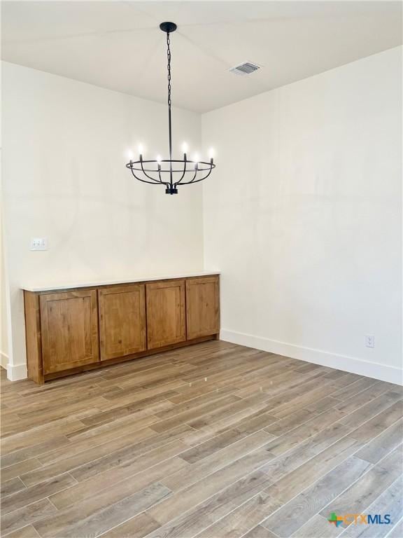 2819 Isaac Cir, Belton, TX 76513 - unfurnished dining area featuring light wood-style floors, a chandelier, and baseboards