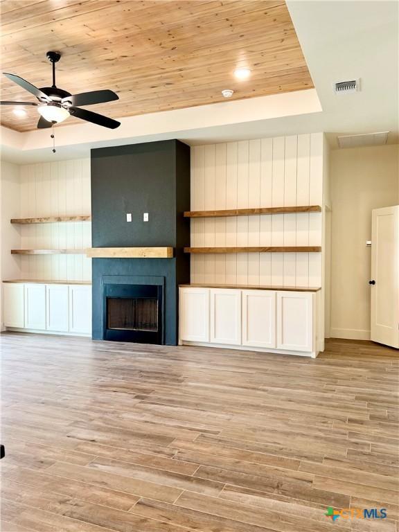 2819 Isaac Cir, Belton, TX 76513 - unfurnished living room with a raised ceiling, a fireplace, a ceiling fan, light wood-style floors, and wooden ceiling