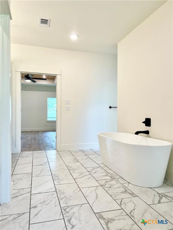2819 Isaac Cir, Belton, TX 76513 - bathroom featuring a soaking tub, marble look tiles, baseboards, ceiling fan, and recessed lighting