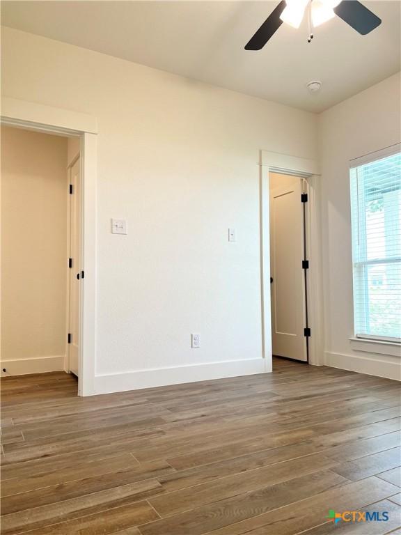 2819 Isaac Cir, Belton, TX 76513 - empty room with wood finished floors, a ceiling fan, and baseboards