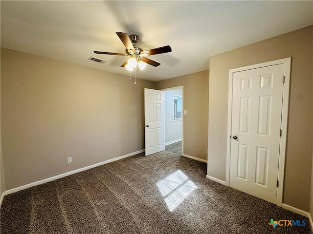 unfurnished bedroom featuring ceiling fan and dark carpet