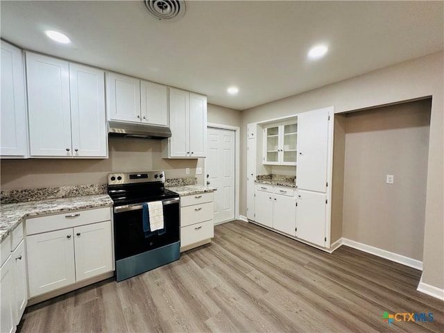 kitchen with white cabinetry, light hardwood / wood-style floors, light stone counters, and electric stove