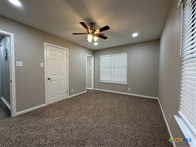 unfurnished bedroom featuring ceiling fan and dark colored carpet