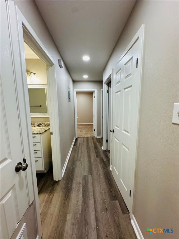 hallway with dark hardwood / wood-style flooring