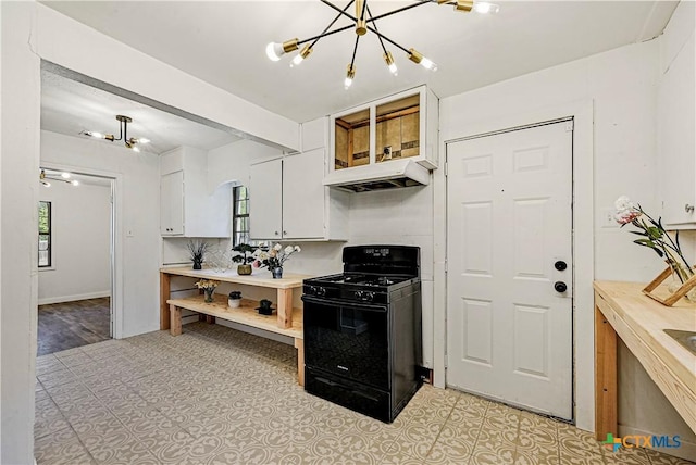 802 Cloud St, Killeen, TX 76541 - kitchen with black range with gas cooktop, under cabinet range hood, a chandelier, white cabinets, and light countertops