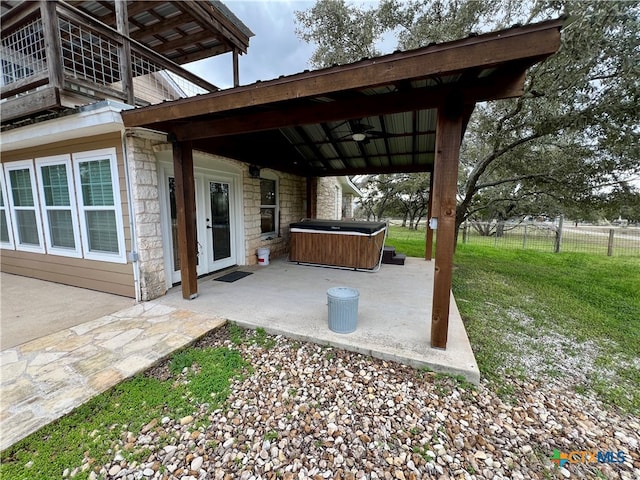 view of patio / terrace with ceiling fan and a hot tub