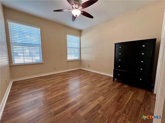 unfurnished bedroom featuring ceiling fan and dark hardwood / wood-style flooring