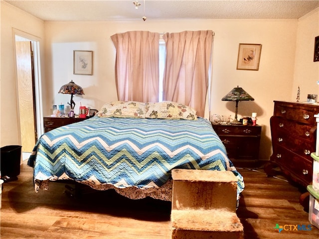 bedroom featuring wood-type flooring and a textured ceiling