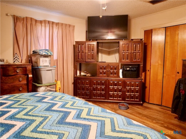 bedroom featuring a textured ceiling, hardwood / wood-style flooring, and a closet