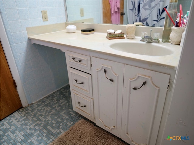 bathroom featuring tile walls, tile patterned flooring, and vanity