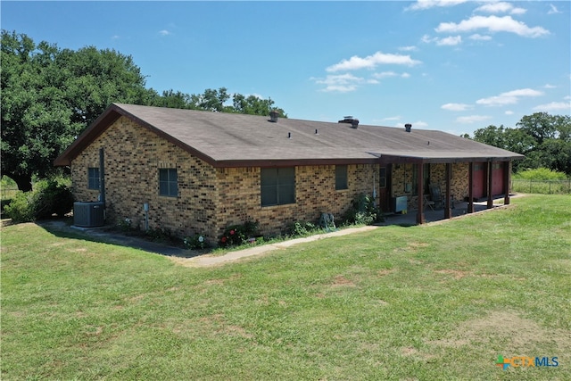 back of property featuring central air condition unit and a lawn