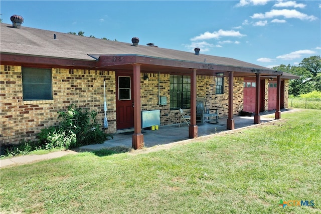 rear view of property with a yard and a patio area