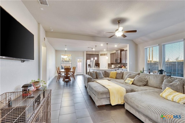 living room with lofted ceiling, recessed lighting, dark tile patterned flooring, visible vents, and a ceiling fan