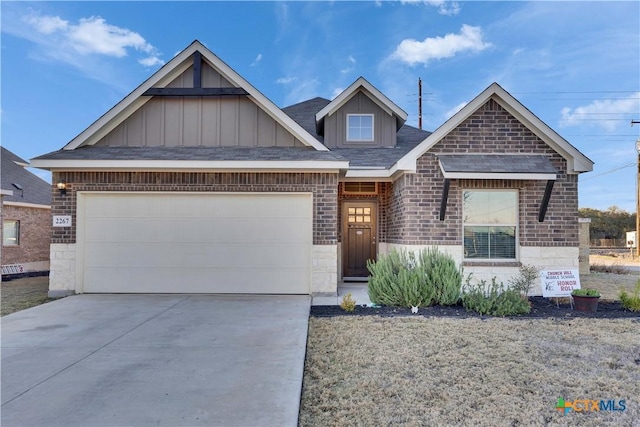 view of front facade with board and batten siding, brick siding, driveway, and an attached garage