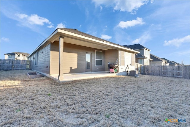 back of property with a fenced backyard, central AC unit, and a patio