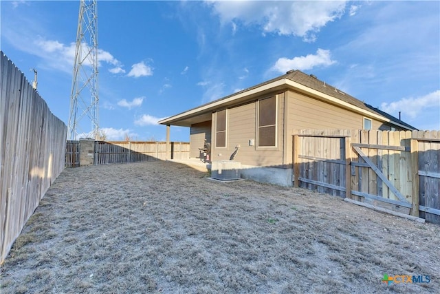 back of house featuring a fenced backyard and cooling unit