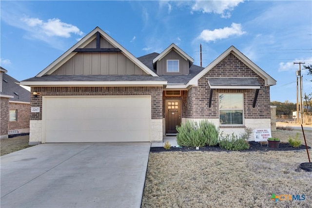 view of front of home featuring board and batten siding, concrete driveway, brick siding, and an attached garage